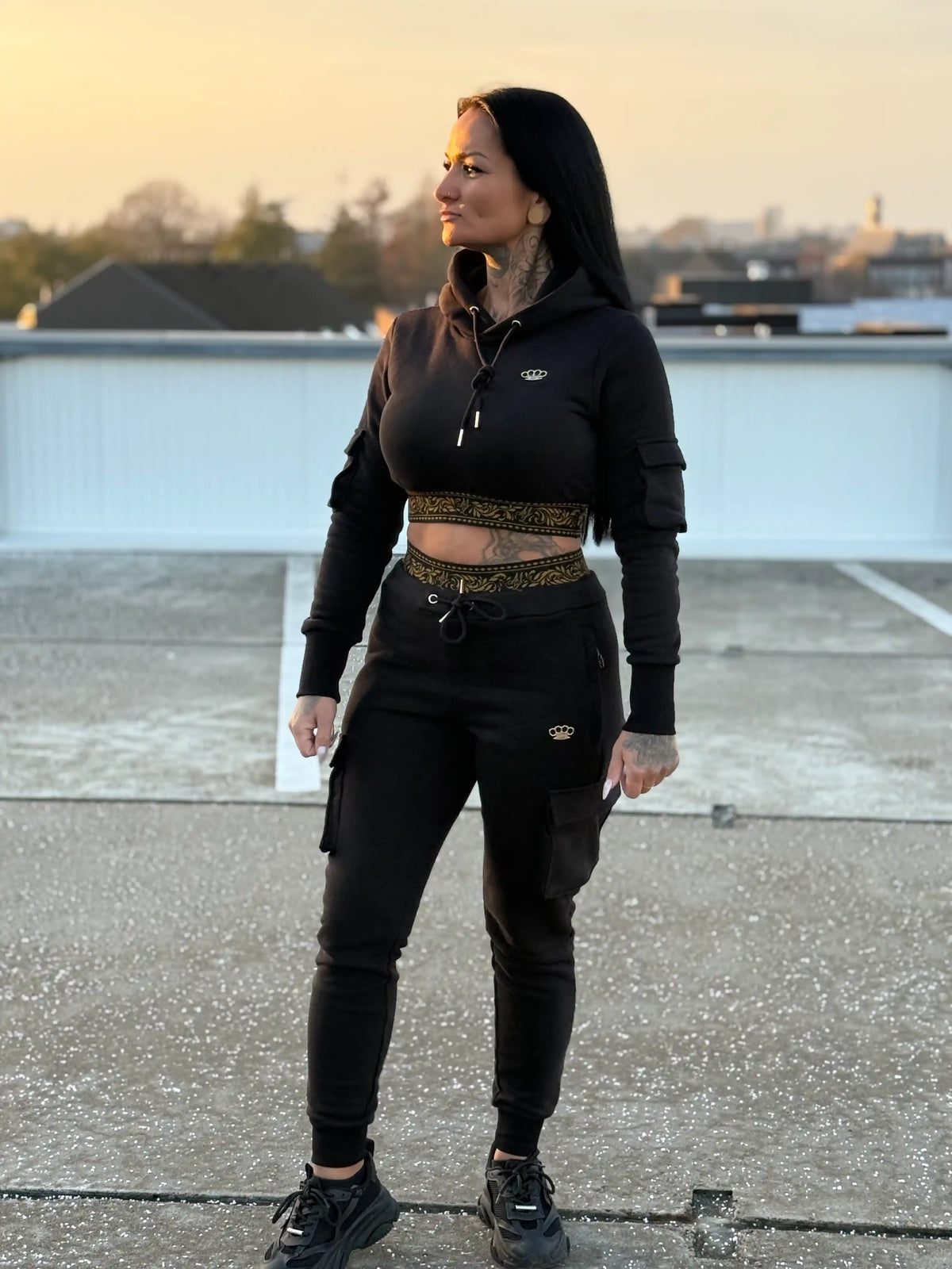 Model in the MVL Meander women's hoodie and joggers on a rooftop at sunset
