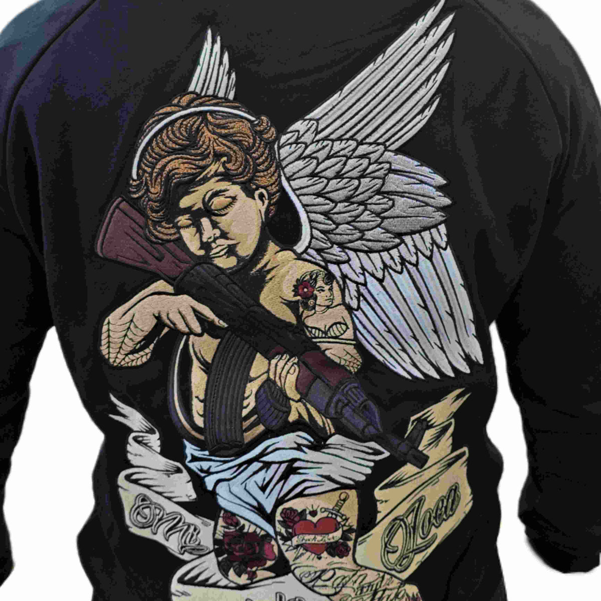 Close-up van het geborduurde Cupid with gun rugstuk: engel met geweer en Mi Vida Loca banner