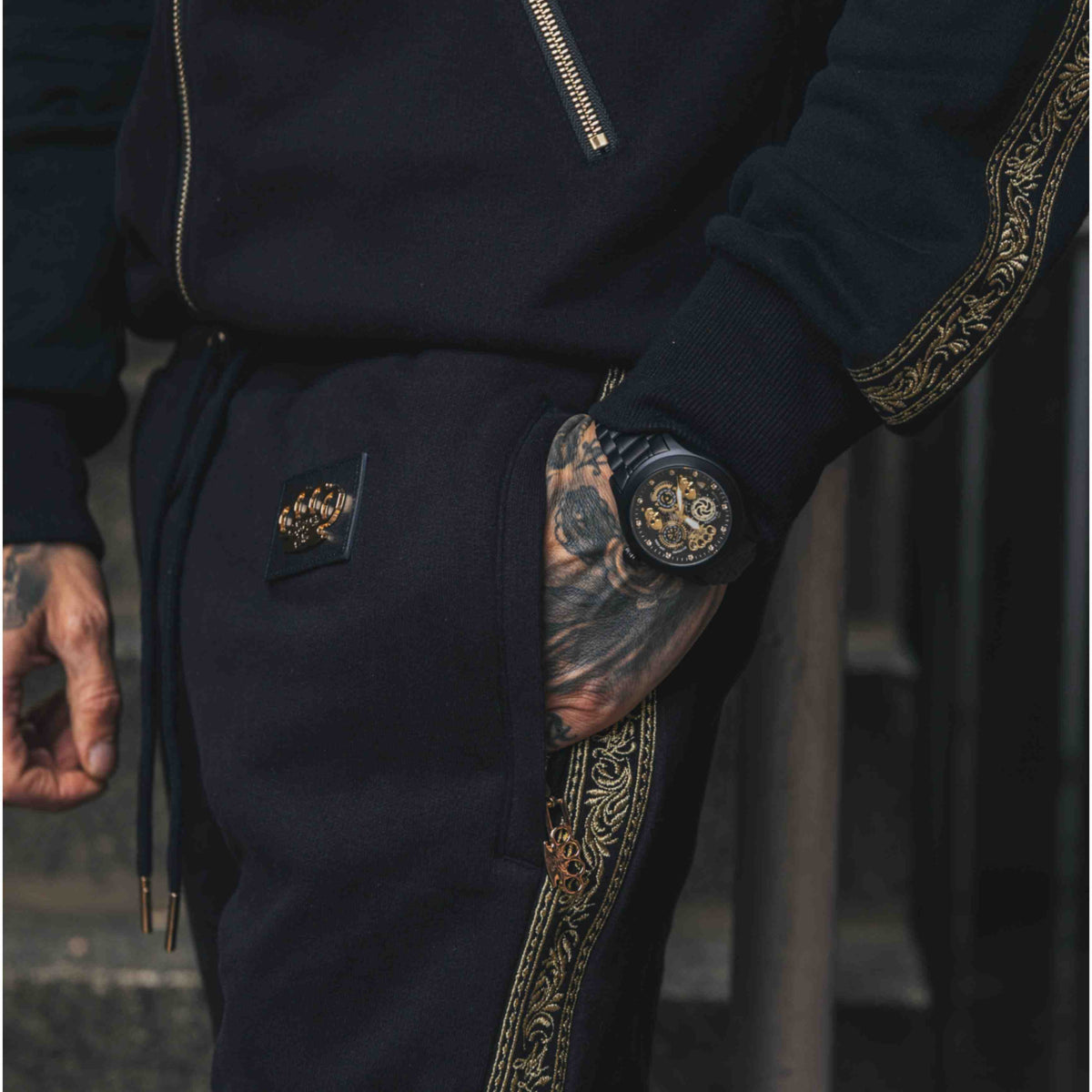 Mi Vida Loca Meander joggingbroek zwart met gouden embroidery band en MVL logo, gedragen door model