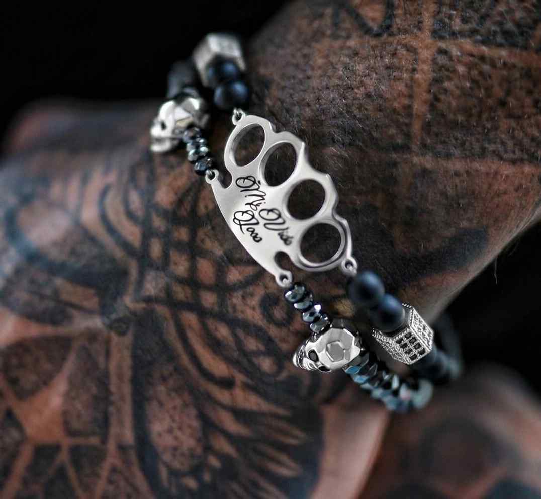 MVL Polygonal skulls Armband schwarz/silber an einem tätowierten Handgelenk, Nahaufnahme