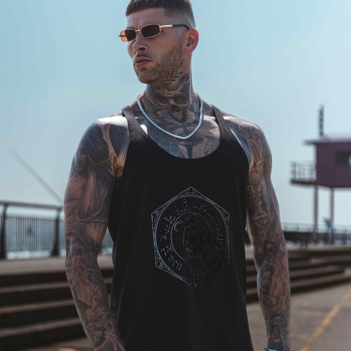 MVL Original streetwear Tanktop schwarz, getragen von Model auf einem Kai, von unten fotografiert