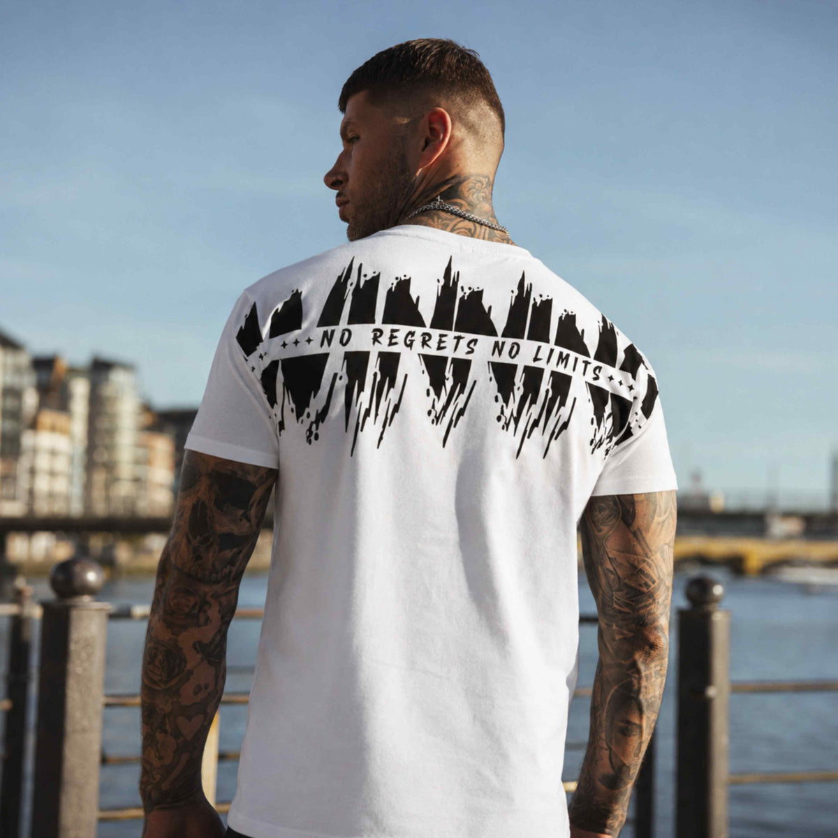 Model von hinten im weißen MVL Winning T-Shirt mit Rückenprint am Wasser