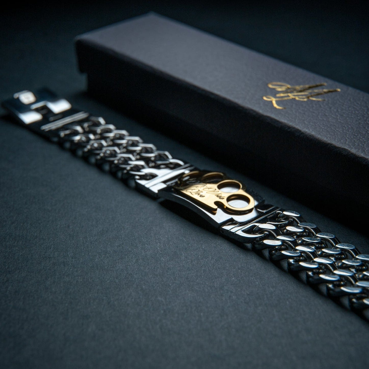 Mi Vida Loca MVL armbånd i sølv med guld MVL logoplade ved siden af den sorte gaveæske