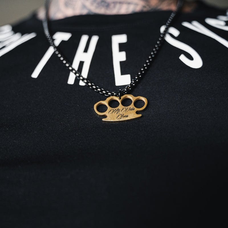 Svart MVL Logo chain med gull MVL-logoanheng båret over en svart T-skjorte
