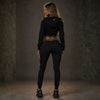 Back of the black MVL Meander women's tracksuit with cropped hoodie, worn by model